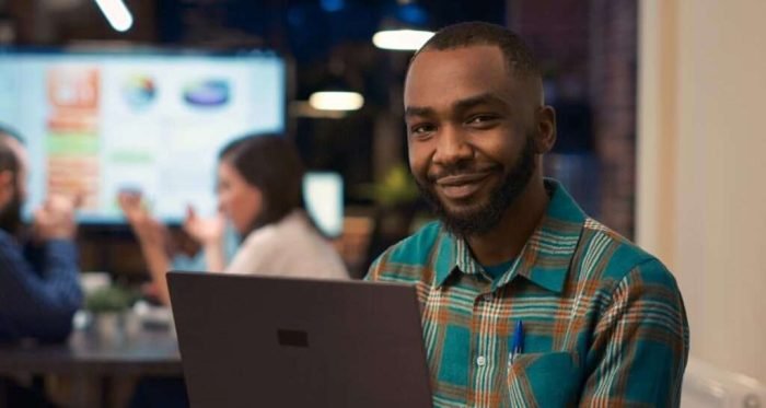 Smiling african american office employee working on laptop portrait Smiling african american office employee working on laptop portrait